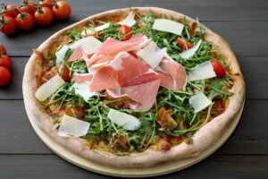 Pizza aux tomates cerises, roquette et jambon cru