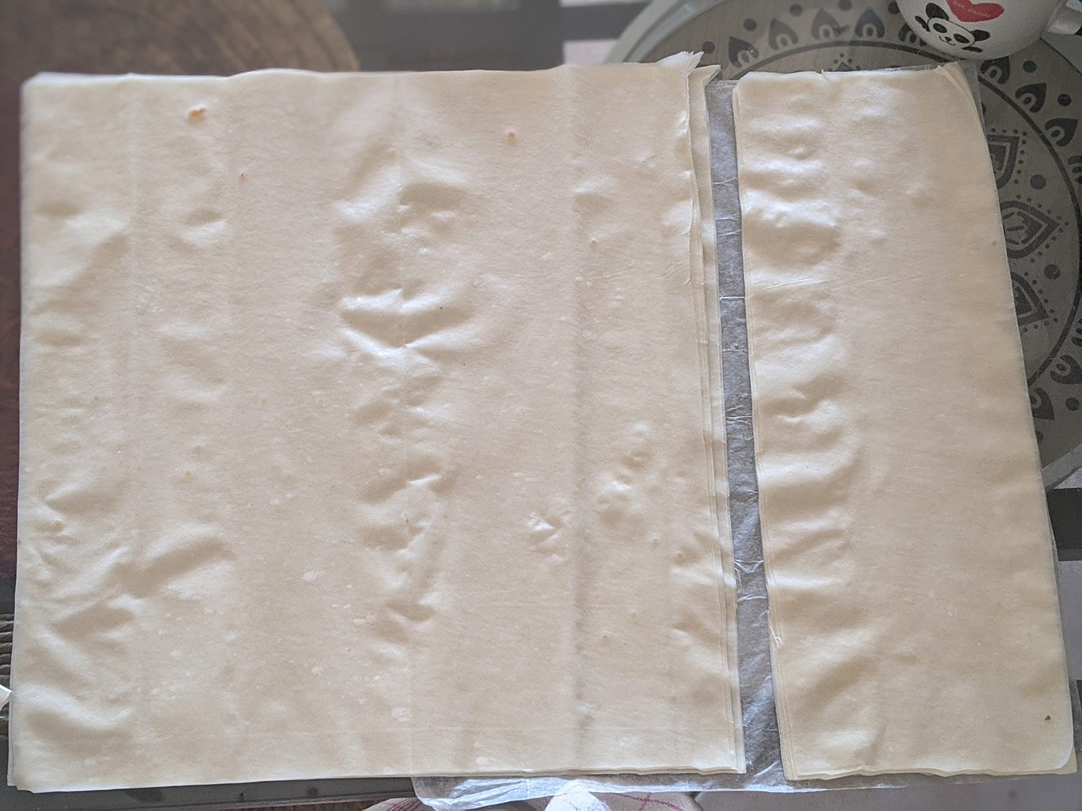 J'étale la pâte filo sur un plan de travail puis je coupe les feuilles de pâte filo en 3 afin de créer de longs rectangles.
